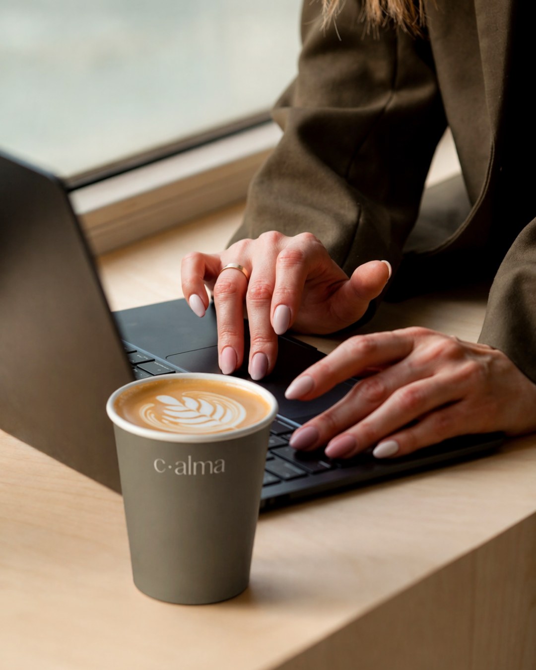 A cĀ·alma coffee cup on the desk at CALMA